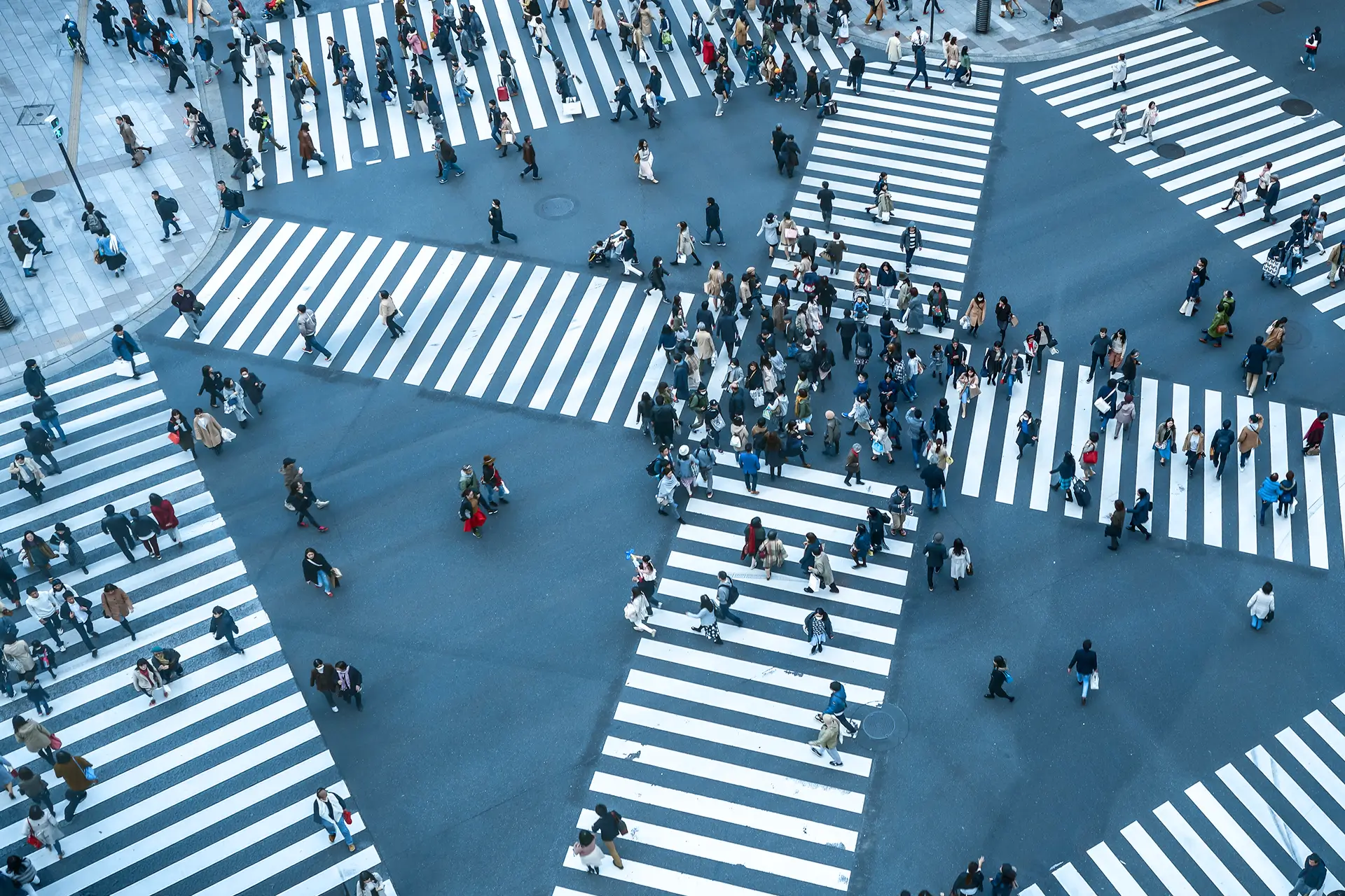 Große Straßenkreuzung mit vielen Menschen als Symbol für komplexe Organisationsstrukturen und Leadership in dynamischen Systemen