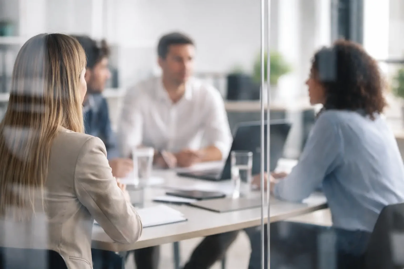 Drei Kolleginnen und Kollegen in einer Besprechung – Business Coaching für Führungskräfte