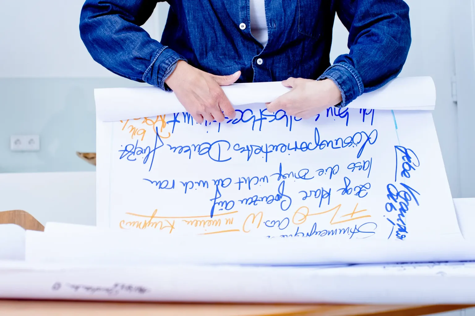 Person hält beschriebene Flipchart-Blätter – strukturierte Prozessarbeit im Business Coaching