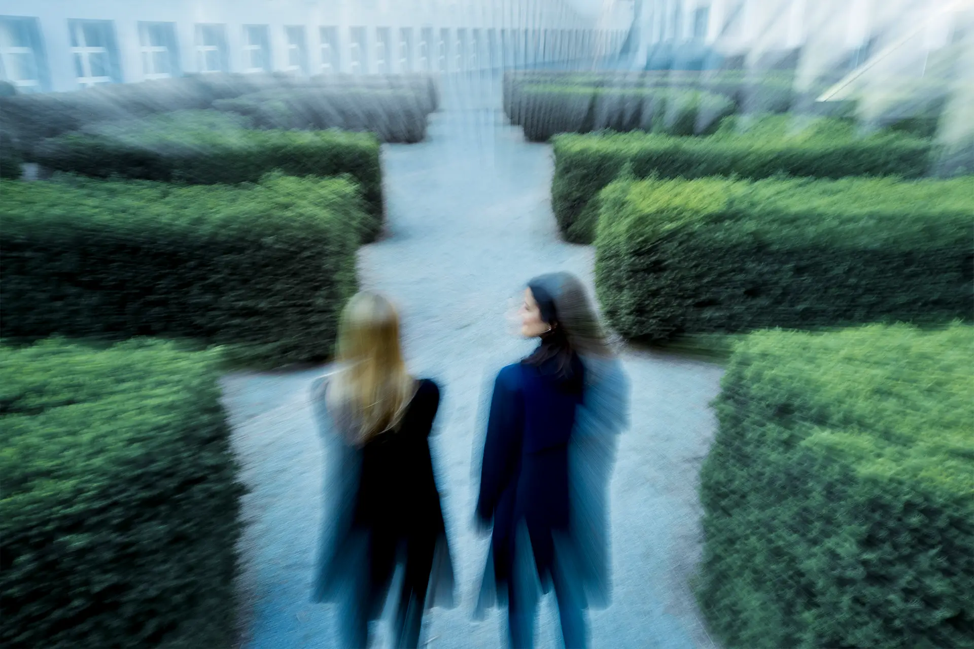 Zwei Personen finden gemeinsam den Weg durch ein Heckenlabyrinth – Führungskräfteentwicklung und Coaching