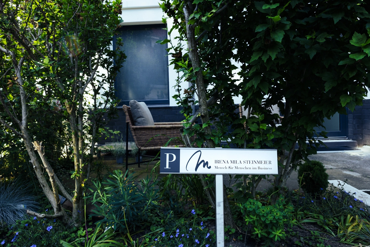 Gartenschild mit Logo Irena Mila Steinmeier vor dem Raum für Menschen in Düsseldorf