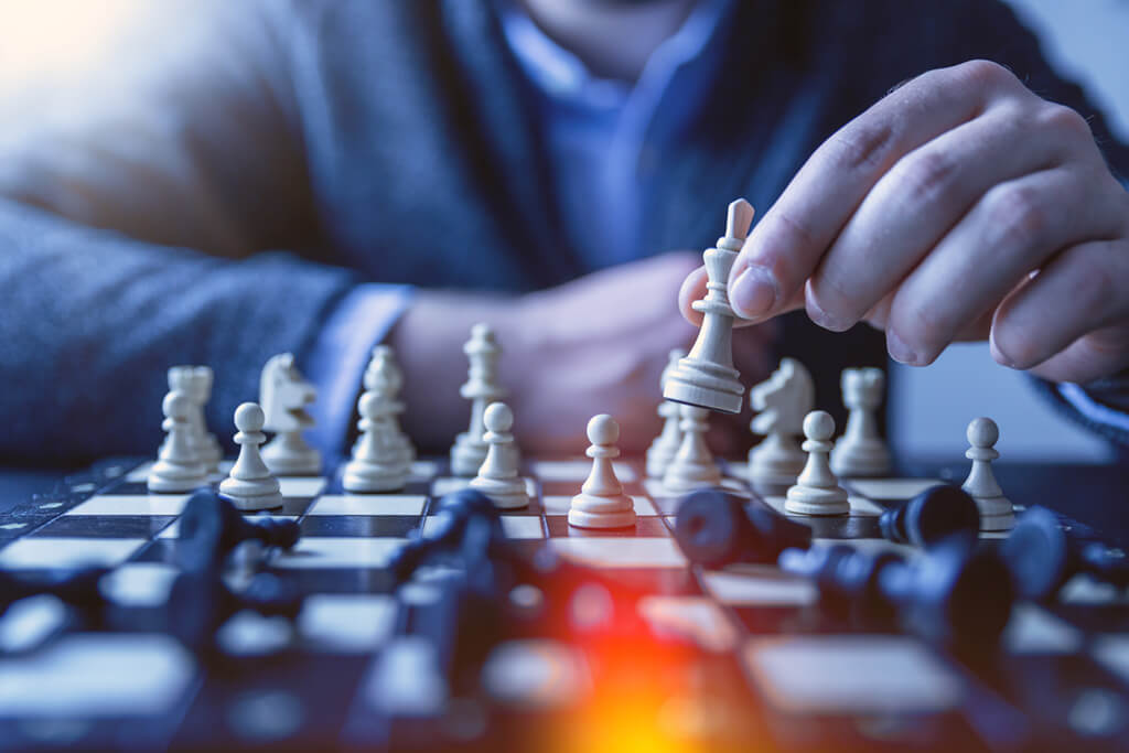 Hand setzt eine Schachfigur – Strategie und Veränderung als das neue Normal